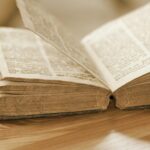 Vintage open book on a wooden table, highlighting old pages and text, perfect for knowledge and history themes.