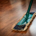 A detailed view of a mop cleaning a wooden floor, showing texture and pattern.