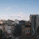 View of decaying urban structures under a clear blue sky, depicting architectural decline.