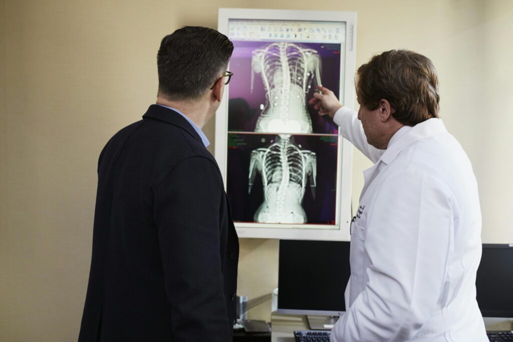 A doctor explains X-ray results to a patient in a clinical setting, highlighting healthcare communication.