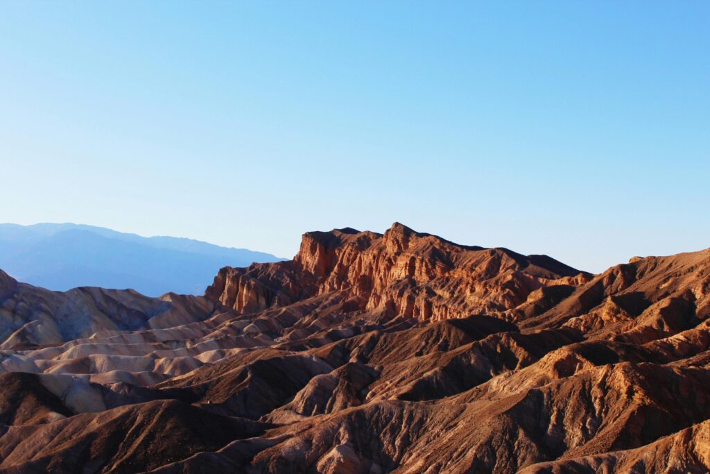 Explore the rugged beauty of Death Valley's desert landscape in warm sunlight.