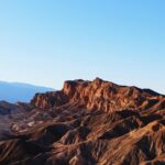 Explore the rugged beauty of Death Valley's desert landscape in warm sunlight.
