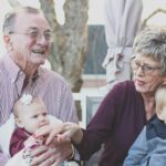 Grandparents spending joyful moments with their grandchildren in an outdoor setting, captured candidly.