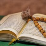 Open Quran with wooden prayer beads, symbolizing Islamic devotion.
