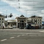 Tram passing in front of Wrocław's historic train station on a cloudy day.