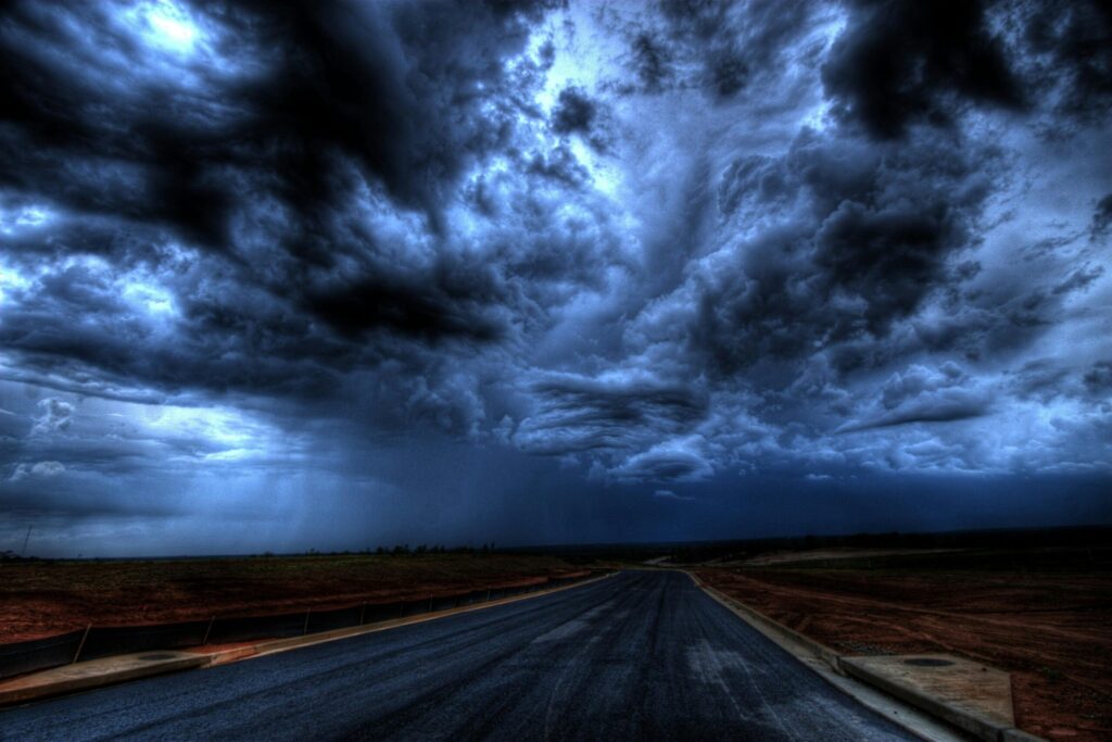 A dramatic stormy sky with dark clouds over an empty road. Nature's power captured at its peak.