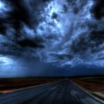 A dramatic stormy sky with dark clouds over an empty road. Nature's power captured at its peak.