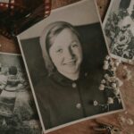 An arrangement of vintage family photos with dried flowers and film negatives, evoking nostalgia.