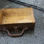 a wooden box sitting on top of a wet ground