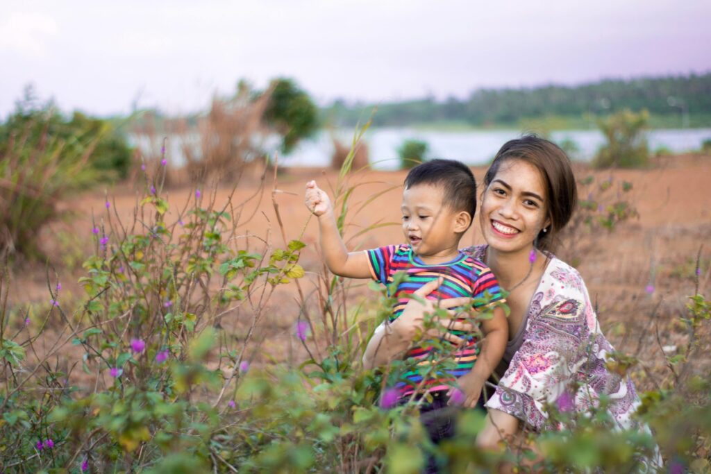 A happy mother and son enjoying a day outdoors in a picturesque countryside setting.