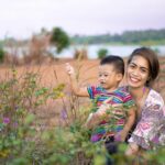 A happy mother and son enjoying a day outdoors in a picturesque countryside setting.