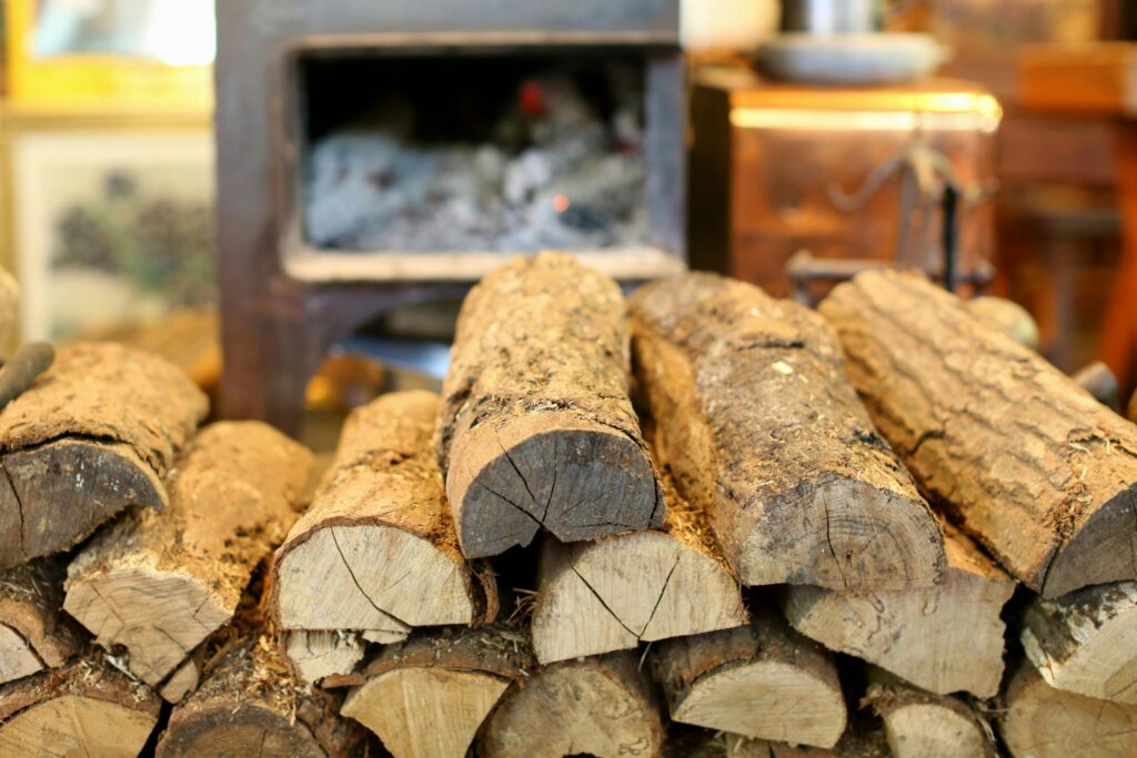 A rustic stack of firewood in front of a cozy indoor fireplace, creating a warm ambiance.