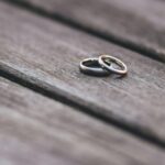 Elegant two-tone wedding rings on rustic wooden surface, symbolizing love and unity.