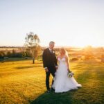 Beautiful couple in wedding attire enjoying a romantic sunset in Sydney, Australia.