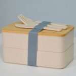 Stylish eco-friendly double layer bento box with bamboo lid and cutlery, perfect for healthy meals.