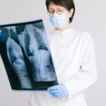 A doctor in protective gear analyzing an X-ray scan indoors.