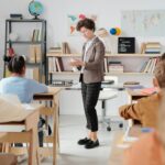 Teacher conducting a classroom lesson with attentive students in a vibrant educational setting.