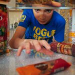 Young boy reaching into refrigerator for a snack. Close-up view indoors.