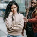 A young couple having a disagreement outdoors, displaying emotions and tension.