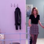 Woman in stylish outfit getting ready to go out from the bedroom.