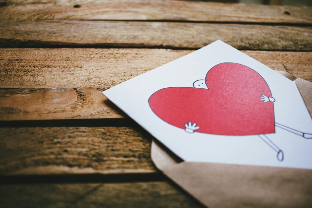 A charming heart illustration on a card inside an envelope placed on a rustic wooden table, perfect for Valentine's Day.