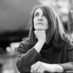 Black and white portrait of a woman gazing thoughtfully outdoors. Emotional and serene.