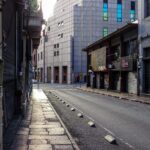 Quiet urban street in Montevideo, Uruguay showcasing closed shops and modern architecture during daytime.
