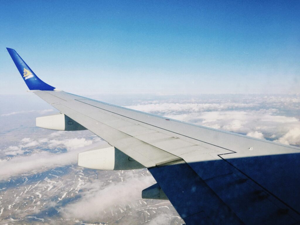 A stunning aerial view of clouds and landscape from an airplane window above Kazakhstan.