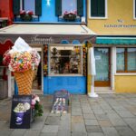 Vibrant gelato shop façade with colorful buildings on a picturesque street.