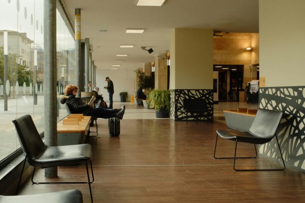 Casual modern seating area with people waiting indoors.