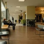 Casual modern seating area with people waiting indoors.