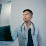 Doctor analyzing X-ray film confidently in a clinical setting.