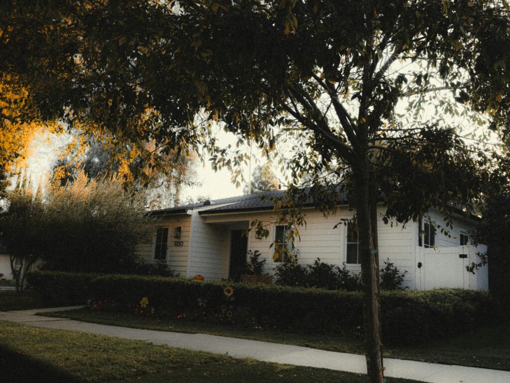 Charming white suburban home with lush greenery and fall colors in Los Angeles.