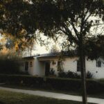Charming white suburban home with lush greenery and fall colors in Los Angeles.