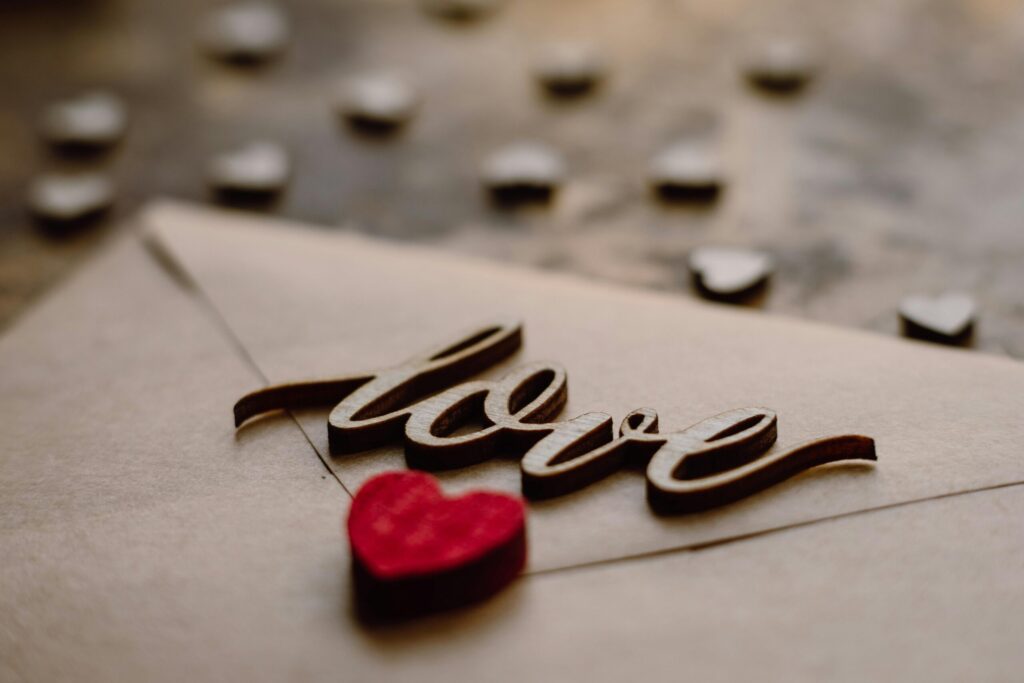 Close-up of a love letter with 'love' text and red heart for Valentine's Day.
