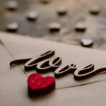 Close-up of a love letter with 'love' text and red heart for Valentine's Day.