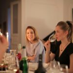 Warm candlelit dinner with friends enjoying wine and conversation.