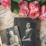 Antique family photographs with pink roses and historic documents.