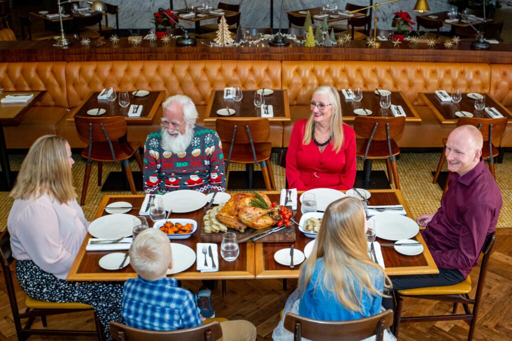 Multi-generational family enjoying a festive meal together at a restaurant in Dubai.