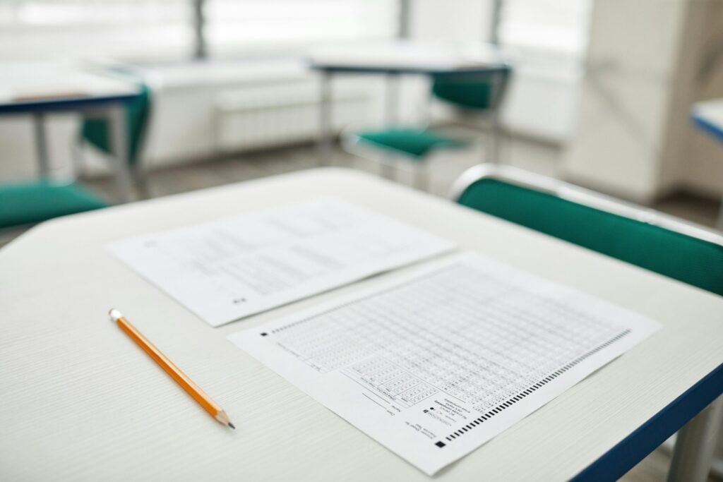 Close-up of exam papers and a pencil on a classroom desk, ready for a test.