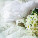 Elegant arrangement of bridal accessories with a white floral bouquet and veil, perfect for wedding themes.