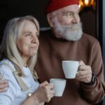 A senior couple embraces while enjoying coffee, symbolizing love and companionship.