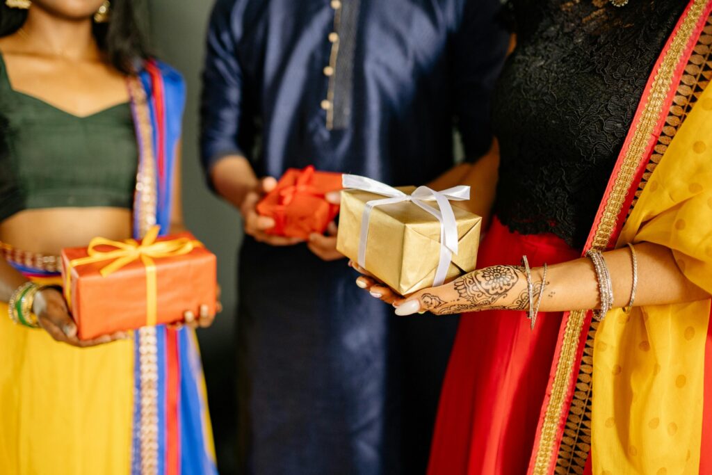 A vibrant scene of people in traditional Indian attire exchanging gifts during a festive celebration, like Diwali.