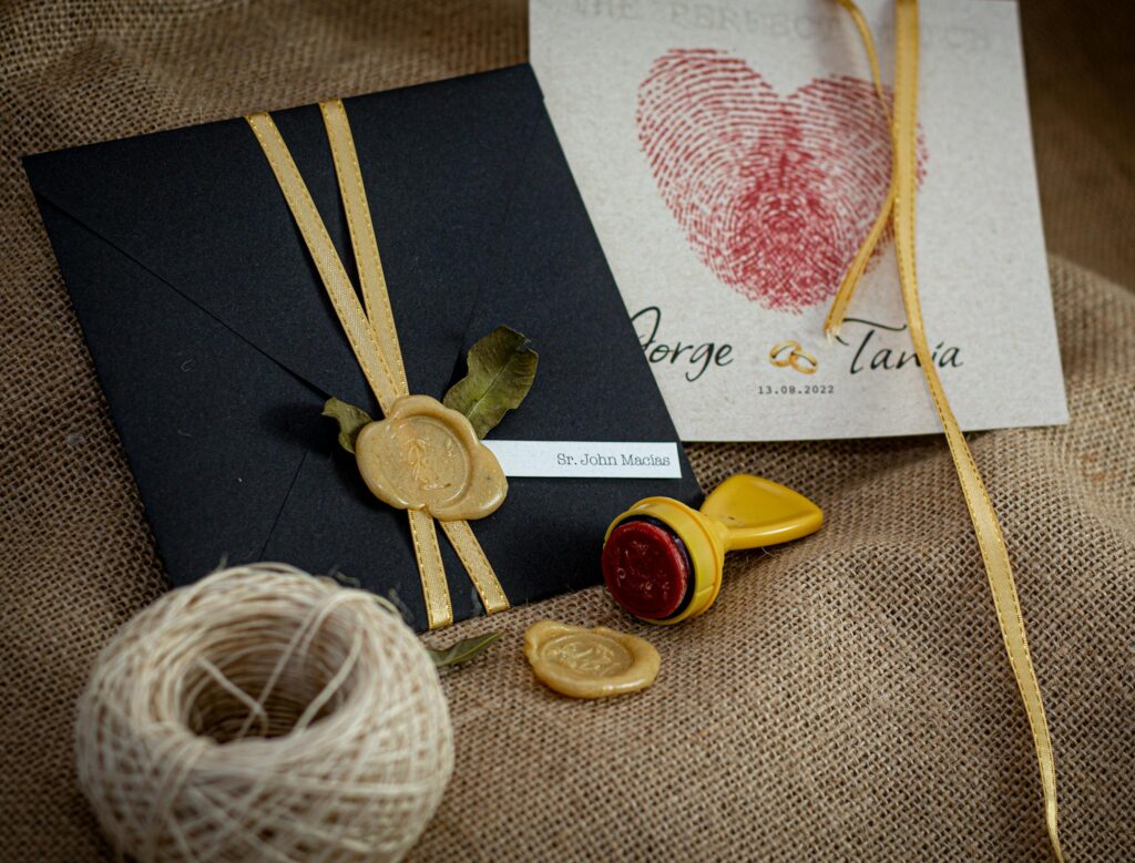Stylish wedding invitation featuring black envelope, wax seal, and personalized card. Perfect for elegant occasions.