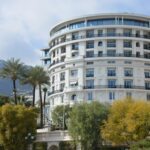 Luxurious round hotel with palm trees, offering an elegant getaway.