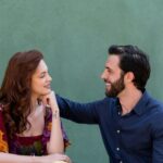 A loving couple smiling at each other outdoors, showcasing affection and happiness.