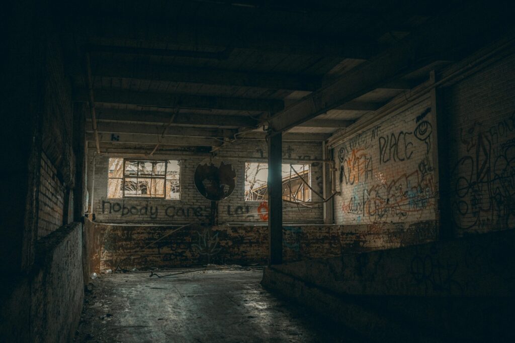 Explore the eerie beauty of an urban abandoned building with graffiti art and broken windows.