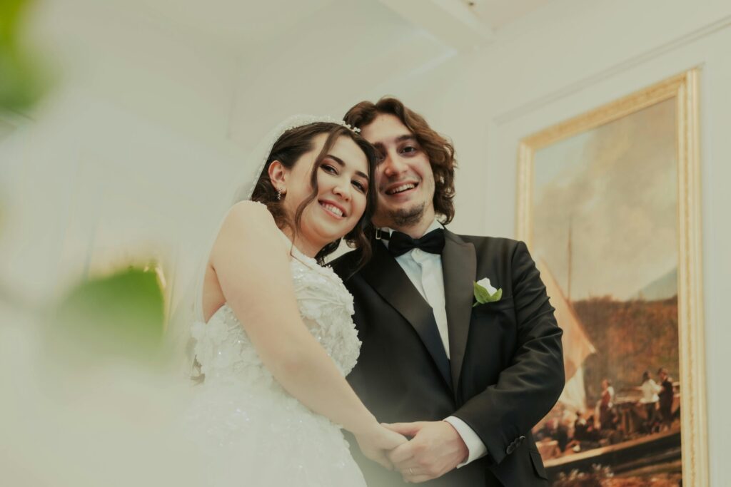 Joyful wedding couple smiling during their special day indoors, capturing love and happiness.