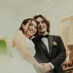 Joyful wedding couple smiling during their special day indoors, capturing love and happiness.