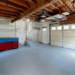 Empty garage with open space and colorful storage cabinets.